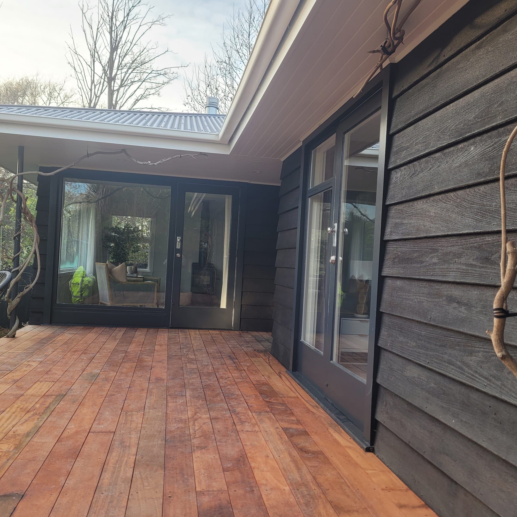 Charcoal exterior repaint with a cedar soffit and deck