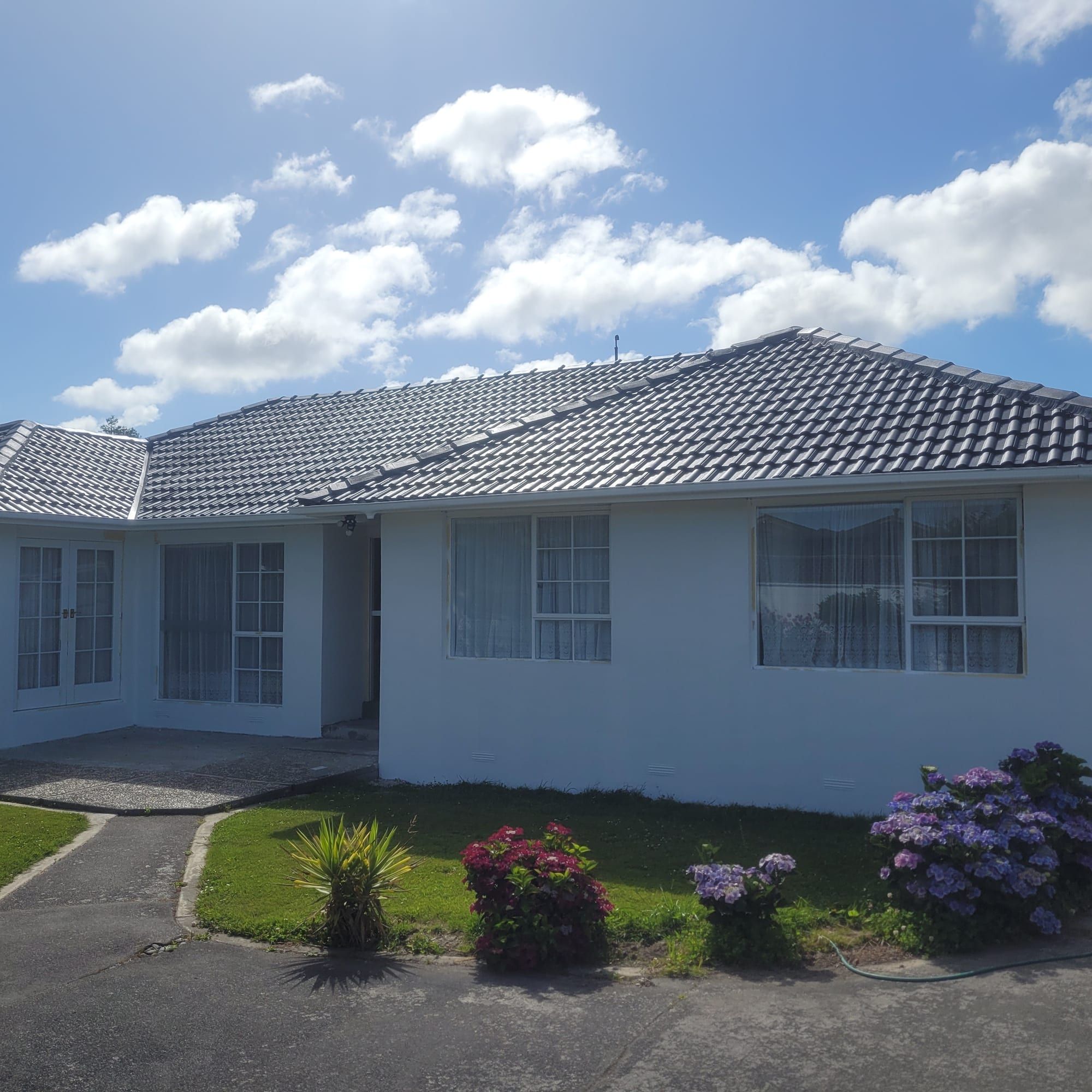 Wide single-storey home repaint under a blue sky